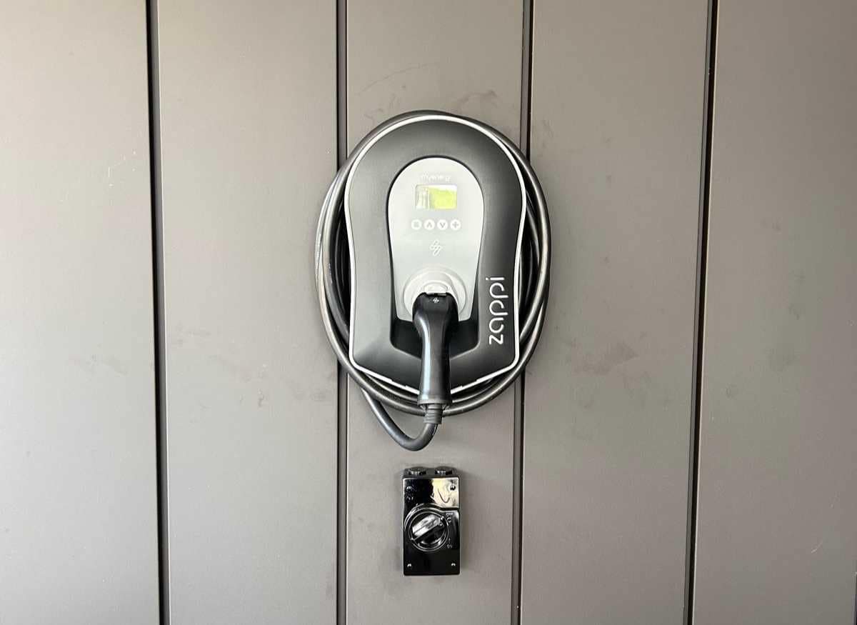 a Zappi EV Charger mounted on a charcoal wall