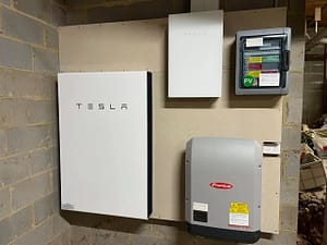 tesla powerwall install on a garage wall with a fronius inverter